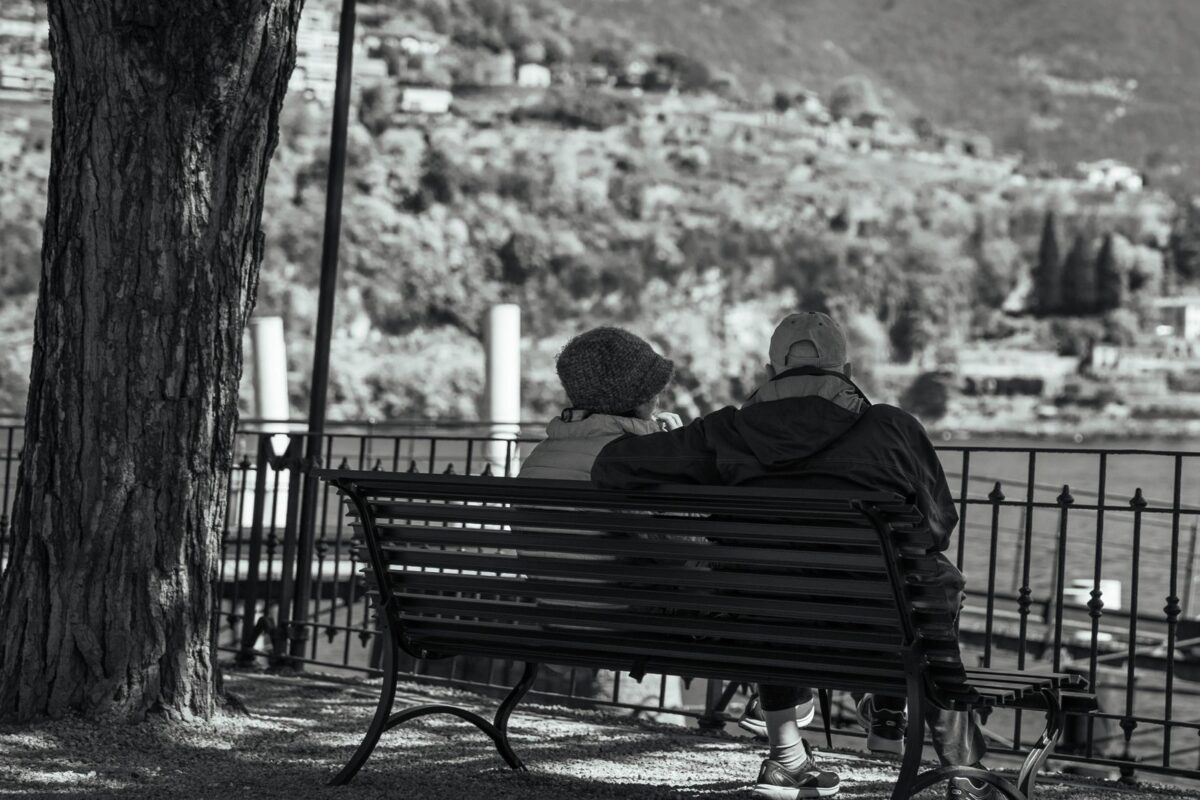Couple âgé assis sur un banc face à un lac